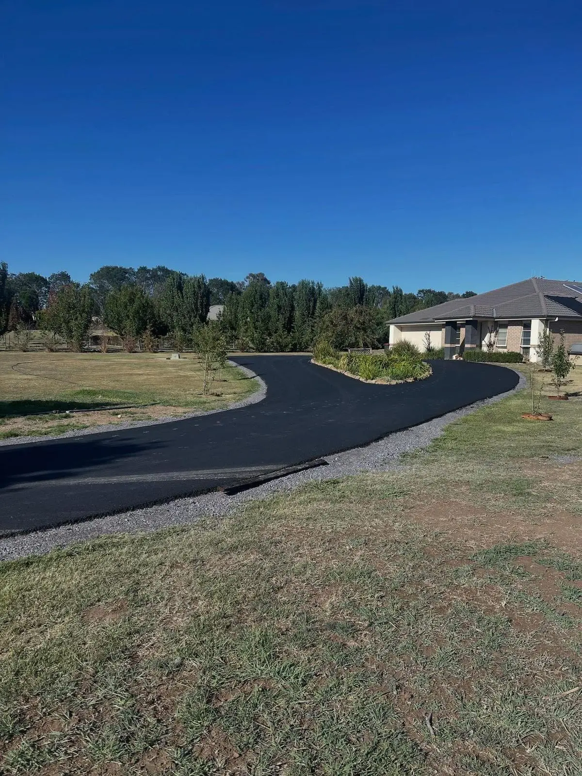 Curved asphalt driveway on large WA property