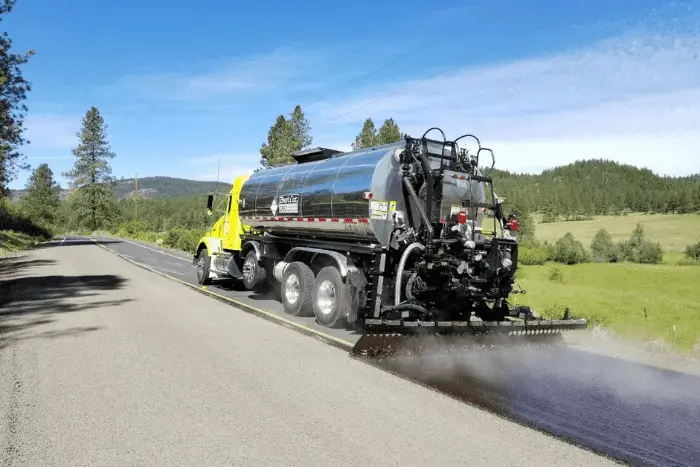 Truck spraying tar for road resurfacing work