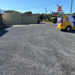 A parked car in a newly constructed commercial asphalt parking lot